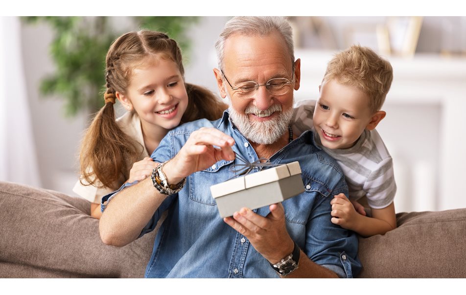 Bestefar åpner gave og barnebarn som ser på